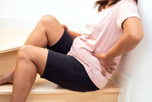 Person holding back while sitting on stairway